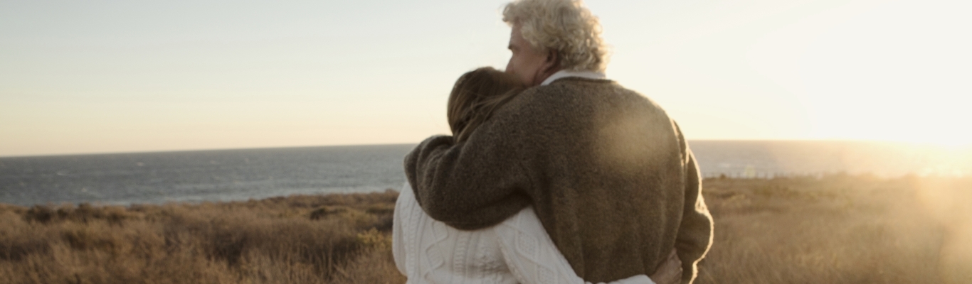 Couple Hugging in Field by Lake