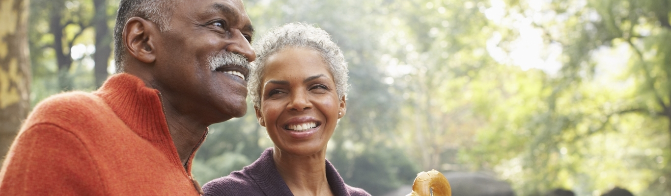 Couple eating pretzels on park bench