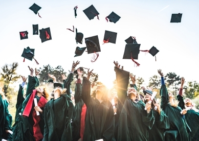 Recent Grads Tossing Graduation Hats